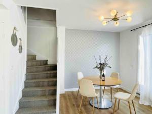 a dining room with a table and a staircase at Marne la Vallée Apartment in Serris +19 photos