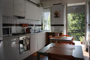 una cocina con armarios blancos y una mesa con sillas. en Lotus B&B en Milán