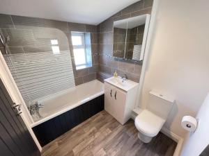 a bathroom with a toilet and a tub and a sink at Edith Haven Tynemouth Fabulous Coastal Holiday Home in Tynemouth