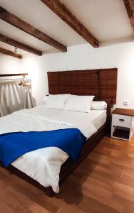 a bedroom with a large bed with a wooden headboard at Awana Farmhouse Dieng in Dieng