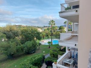 un balcón de una casa con vistas a la piscina en Studio Golf Riviera - Axelle Loc'Appart en Mandelieu-la-Napoule