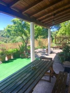 a wooden bench sitting under a pergola at Casa rural Buxo Ribeira Sacra in Carballedo