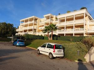 a white car parked in front of a large building at Studio Golf Riviera - Axelle Loc'Appart in Mandelieu-La Napoule
