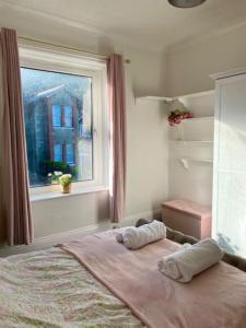 Peaceful Coastal Apartment في فنتنور: غرفة نوم بسرير ومخدتين ونافذة