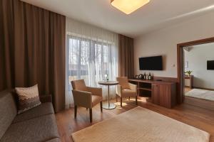 a living room with a couch and a table with chairs at Penzión Skalica in Skalica