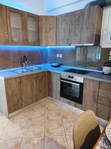 a kitchen with wooden cabinets and a sink at Avanda Corfu in Corfu