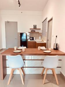 une cuisine avec un grand comptoir en bois et 2 chaises dans l'établissement New l 2BR I 2-6Pax I Jonker 5 Min I SeaView I AmberCove, à Malacca