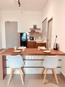 a kitchen with a large wooden counter with two chairs at New l 2BR I 2-6Pax I Jonker 5 Min I SeaView I AmberCove in Melaka