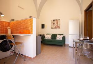 a living room with a green couch and a table at Sogni a Sud - The Fab Stay in Mesagne
