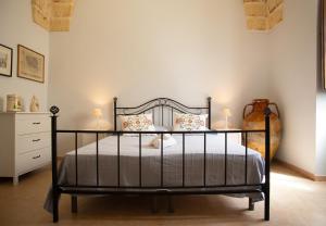 a bedroom with a black bed and a dresser at Sogni a Sud - The Fab Stay in Mesagne