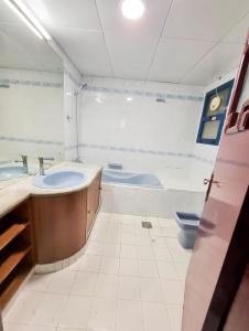 uma casa de banho com 2 lavatórios, uma banheira e um WC. em Abu Dhabi Center - Unique Bed Space em Abu Dhabi