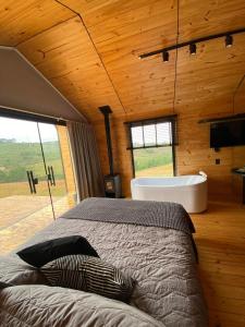 a bedroom with a bed and a tub in a room at Nordic Cabanas in Cambara do Sul