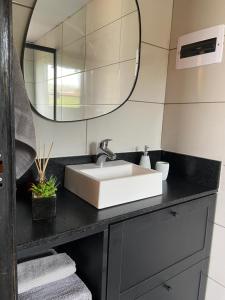La salle de bains est pourvue d'un lavabo et d'un miroir. dans l'établissement Nordic Cabanas, à Cambará