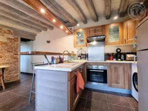 a large kitchen with wooden cabinets and appliances at La Maison de Nicole in Mousseaux-sur-Seine