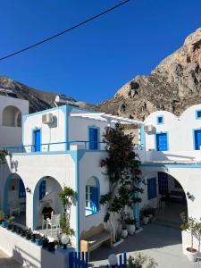 eine Reihe weißer Gebäude mit blauen Fenstern in der Unterkunft Anna Maria Rooms Santorini in Perissa