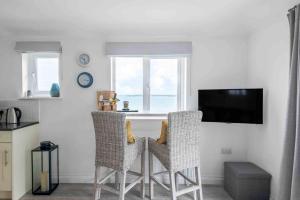 a kitchen with a table with two chairs and a television at Little Haven St Ives in St Ives