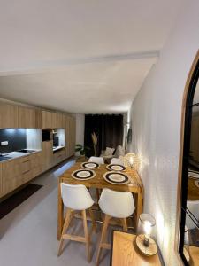 a kitchen and dining room with a wooden table and chairs at Le Studio de la Digue in Wissant