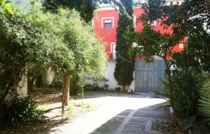 une cour avec une maison rouge et une clôture dans l'établissement N28, à Xàtiva