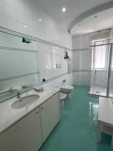 een witte badkamer met een wastafel en een toilet bij Campanile Maison in Napels