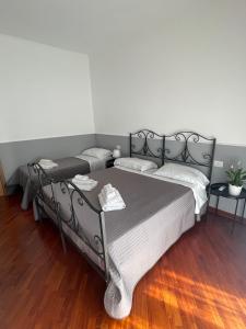 een slaapkamer met 2 bedden en een houten vloer bij Campanile Maison in Napels