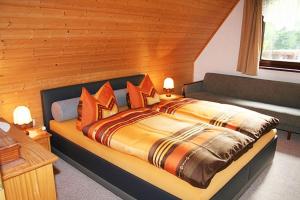 a bedroom with a large bed with orange pillows at Ferienzimmer Hämer in Prerow