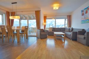 ein Wohnzimmer mit einem Sofa, einem Tisch und Stühlen in der Unterkunft Apartment Igor - by Alpen Apartments in Piesendorf