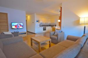 sala de estar con sofá, sillas y TV en Apartment Igor - by Alpen Apartments, en Piesendorf