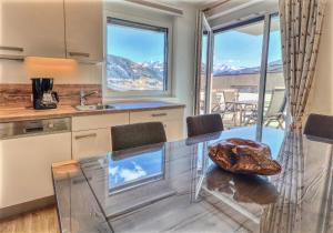 een keuken met een glazen tafel en uitzicht bij Apartment Konstanzia - by Alpen Apartments in Zell am See