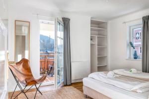 a bedroom with two beds and a chair in it at Villa Alpenbach - by Alpen Apartments in Zell am See
