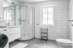 a bathroom with a shower and a toilet and a sink at Villa Alpenbach - by Alpen Apartments in Zell am See