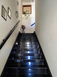 a stairway with blackestones and a white wall at Silia's Maisonette in Marsaskala