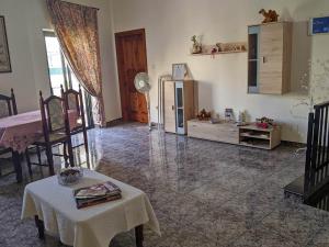 ein Wohnzimmer mit einem Tisch und Stühlen sowie einem Kühlschrank in der Unterkunft Silia's Maisonette in Marsaskala