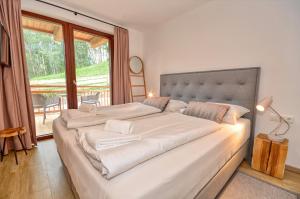 カプルーンにあるSki-in Ski-out Chalet Maiskogel 17C - by Alpen Apartmentsの窓付きの客室で、白い大型ベッド1台が備わります。