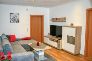 - un salon avec un canapé et une télévision dans l'établissement Apartment Birke 2 - by Alpen Apartments, à Bad Gastein