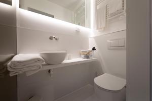 a white bathroom with a sink and a toilet at Terra d'Ombra Bed&Breakfast in San Gimignano