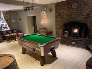 a living room with a pool table and a fireplace at The Sycamore Inn in Birch Vale