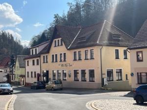 a building with cars parked in front of a street at Thüringer Hof in Ziegenrück