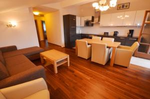 ein Wohnzimmer mit einem Sofa und einem Tisch sowie eine Küche in der Unterkunft Select Top 10 - by Alpen Apartments in Piesendorf