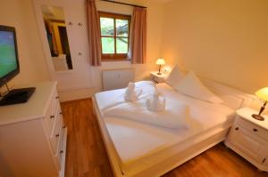 Schlafzimmer mit einem großen weißen Bett und einem Flachbild-TV in der Unterkunft Select Top 10 - by Alpen Apartments in Piesendorf