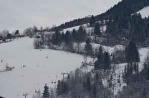 un groupe de personnes skier sur une piste enneigée dans l'établissement Apartment Lisa - by Alpen Apartments, à Zell am See