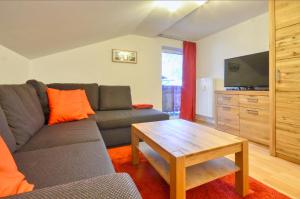 a living room with a couch and a tv and a table at Apartment Lisa - by Alpen Apartments in Zell am See