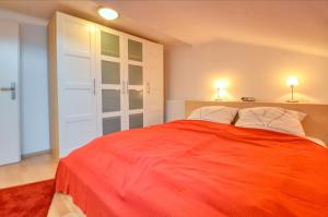 a bedroom with a large red bed with two lamps at Apartment Lisa - by Alpen Apartments in Zell am See
