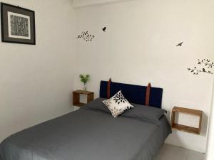 1 dormitorio con 1 cama con pájaros en la pared en Casa Tierra Mojada, en Coatepec