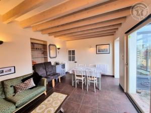 ein Wohnzimmer mit einem Sofa und einem Tisch in der Unterkunft La Maison de Nicole in Mousseaux-sur-Seine