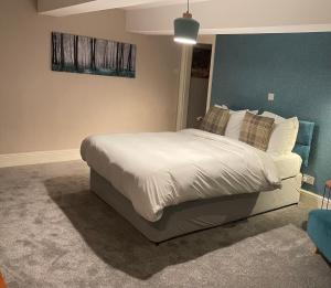 1 dormitorio con 1 cama con sábanas y almohadas blancas en The Sycamore Inn en Birch Vale