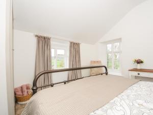 een slaapkamer met een bed in een kamer met ramen bij Skylarks in Looe