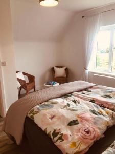 a bedroom with a large bed with a floral blanket at Lakeview Holiday Home Whitegate in Whitegate