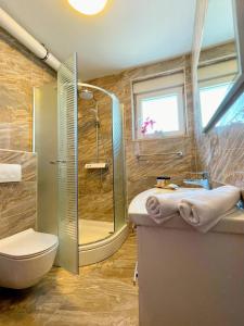 a bathroom with a shower and a toilet and a sink at SeaScape Deluxe Residence in Pješčana Uvala 