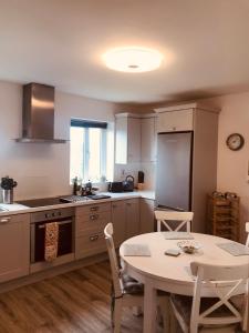 a kitchen with a table and a table and chairs at Lakeview Holiday Home Whitegate in Whitegate