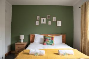 a green bedroom with a bed with two towels on it at Cottenham - City Centre with Free Private Parking 2 toilets 4 Bedroom Sleeps 6 in Newcastle upon Tyne